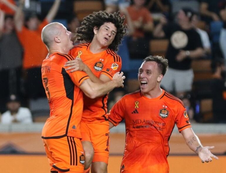 Iván Franco (c) es congratulado por sus compañeros tras anotar un gol para el Houston Dynamo.