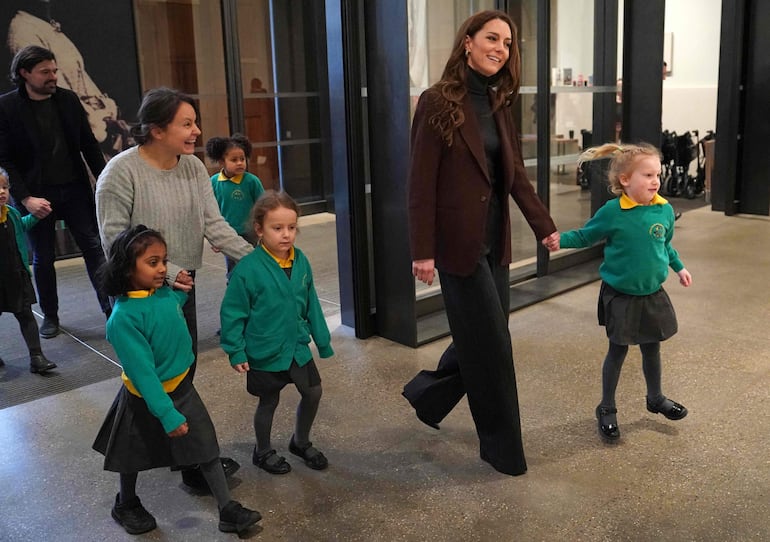 La princesa de Gales toma la mano de una alumna de la escuela primaria All Souls CE cuando llega para lanzar un nuevo proyecto del Centro de la Fundación Real para la Primera Infancia. (Arthur EDWARDS / POOL / AFP)