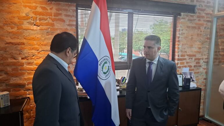 Tadeo Rojas del MDS (mirando a la bandera paraguaya) y Gustavo Villate del Mitic, tras la reunión por las denuncias de personas fallecidas en lista de pensión de adultos mayores.