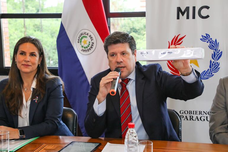 El ministro de Industria, Javier Giménez, muestra la cantidad de hojas que las empresas maquiladoras dejarían de utilizar al digitalizar gestiones con el INTN.