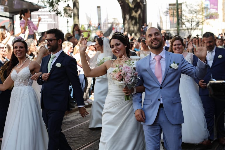 Las parejas de recién casados ​​desfilan por las calles después de casarse durante una ceremonia tradicional, denominada las 'Bodas de 'San Antonio' en la Catedral de Lisboa, Portugal.