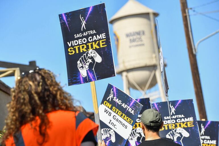 Actores de doblaje en videojuegos, artistas de captura de movimiento y otros protestan el jueves fuera de la sede de Warner Bros. Games en Burbank, California.