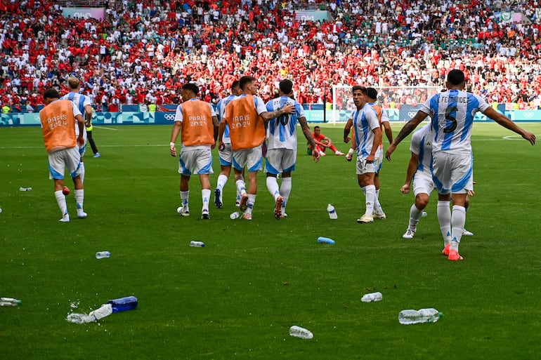 Los jugadores de Argentina celebra un gol bajo una lluvia de botellas en el partido frente a Marruecos por la primera fecha del Grupo B de los Juegos Olímpicos París 2024 en el Geoffroy-Guichard Stadium, en Saint-Etienne, Francia. 