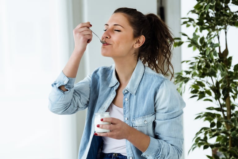 Mujer comiendo un yogur.