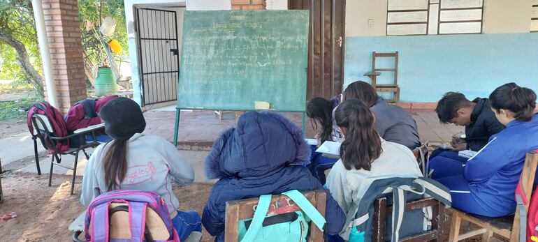 Estudiantes de la escuela Nueva Asunción de Chacó'i dan clases bajo un árbol y comparten la pizarra entre varos grados.