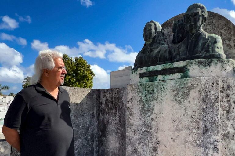Mario Darias, de 66 años, escritor, músico y poeta, observa los bustos de bronce de la tumba del matrimonio Margarita Pacheco y Modesto Canto, conocida como "La Tumba del Amor", en el Cementerio Colón de La Habana.