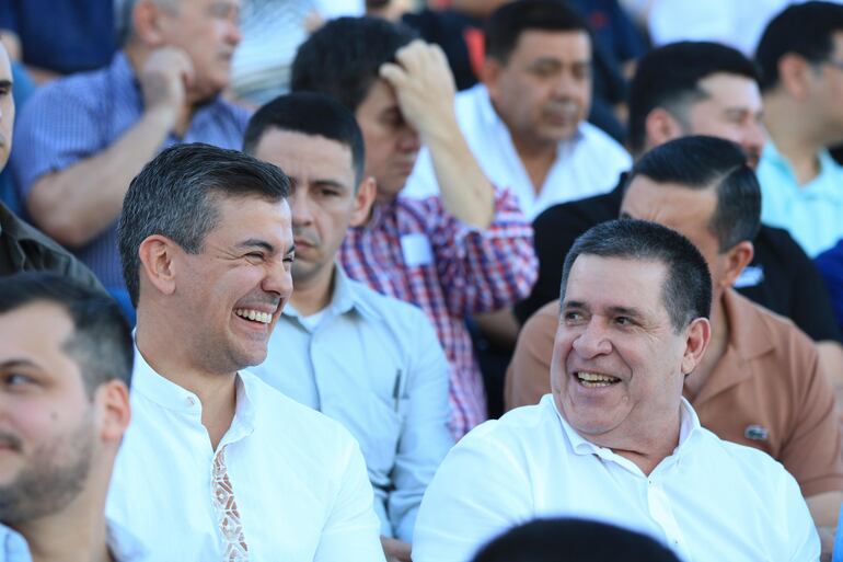 Santiago Peña y Horacio Cartes sonrientes durante el partido entre Libertad y Luqueño en el estadio de Carapeguá con inauguración de lumínica. (gentileza).