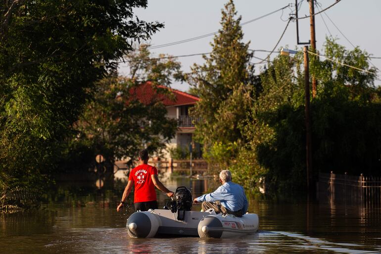 Un voluntario lleva a un residente afectado por las inundaciones a un lugar seguro, después de que la tormenta 'Daniel' arrasara Grecia central, en Koskinas Karditsa.