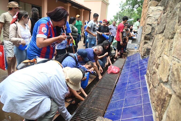 Los peregrinos se refrescan con el agua milagrosa del Pozo de la Virgen.