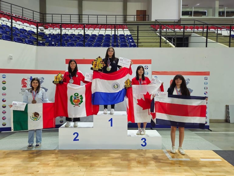 La paraguaya WCM Renata Mayeregger (centro) celebra el oro que obtuvo en la rama femenina.