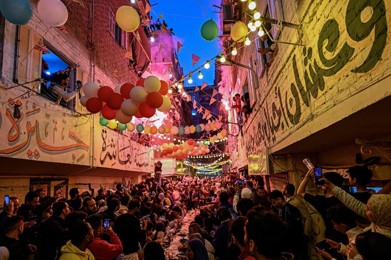 El ramadán en Egipto. Musulmanes comparten una cena comunitaria para romper el ayuno, el Iftar. (AFP)