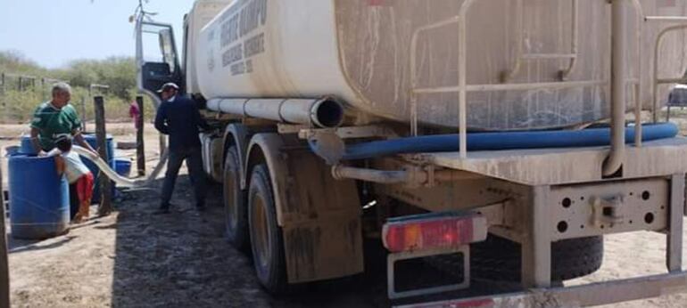 Un poblador de la localidad de San Carlos, distante a 100 kilómetros del casco urbano de Fuerte Olimpo, procede a bajar el agua tratada, llevada por el camión cisterna.