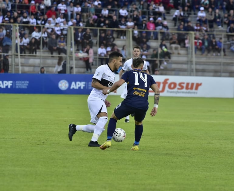 Fernando Cardozo de Olimpia, disputa el balón con Sergio Mendoza, de Trinidense.