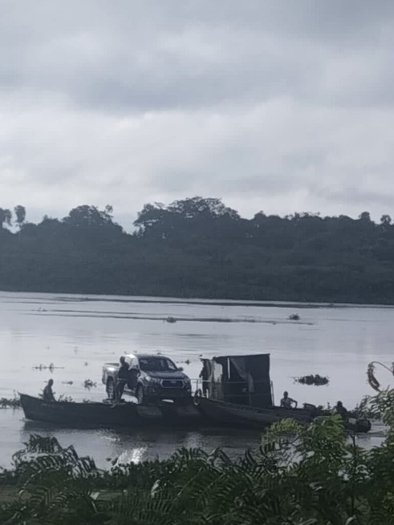 Una lujosa camioneta es llevada en una pequeña embarcación hacia territorio boliviano.