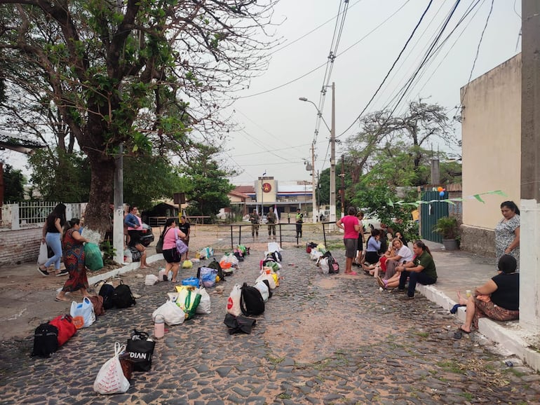 Con bolsones guardan lugar en la fila para ingresar de visita en la Penitenciaría de Tacumbú.