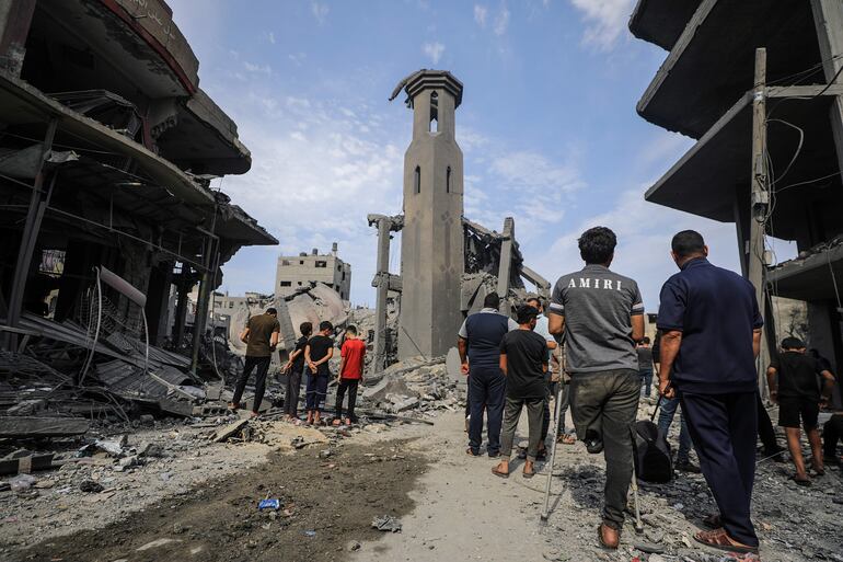 Palestinos se reúnen entre los escombros de una zona destruida después de los ataques aéreos israelíes en la ciudad de Gaza, el 9 de octubre de 2023. Paraguay aún no puede confirmar oficialmente la muerte de dos compatriotas residentes en Israel, cerca de la frontera con Gaza.