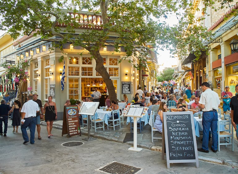 Una terraza de un restaurante griego en el barrio de Plaka en la ciudad de Atenas, ofrece comida típica griega en una pizarra. Región de Ática, Grecia