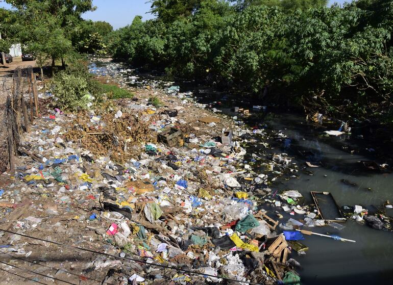 Un basural cubre el arroyo que cruza el Bañado Sur y llega así al río Paraná.