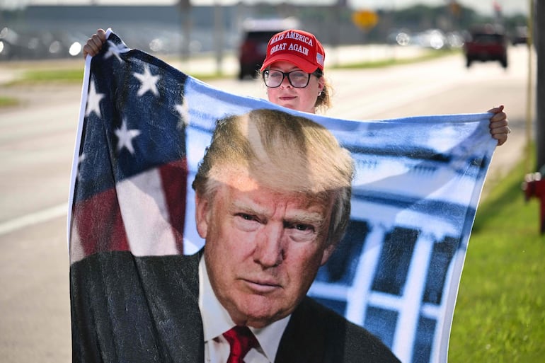 Un partidario del expresidente de Estados Unidos y candidato presidencial republicano Donald Trump espera en el Aeropuerto Internacional Mitchell de Milwaukee, Wisconsin, el 14 de julio de 2024, para intentar ver el aterrizaje de su avión.