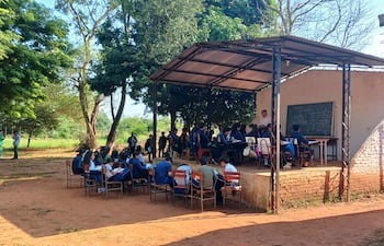 Alumnos reciben clases en el escenario y bajo árboles en una escuela de Coronel Oviedo.