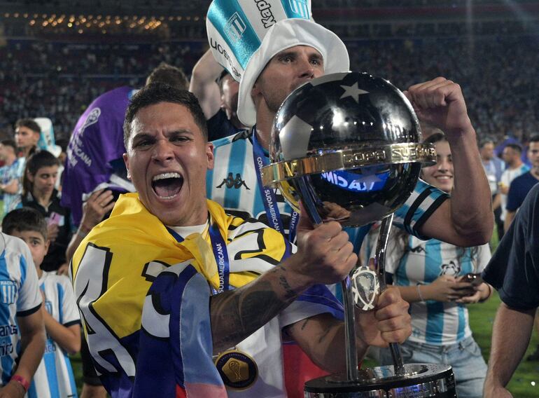 Racing's Colombian midfielder #08 Juan Fernando Quintero celebrate with the trophy after winning the Copa Sudamericana final football match between Argentina's Racing and Brazil's Cruzeiro at La Nueva Olla Stadium in Asuncion on November 23, 2024. (Photo by JUAN MABROMATA / AFP)