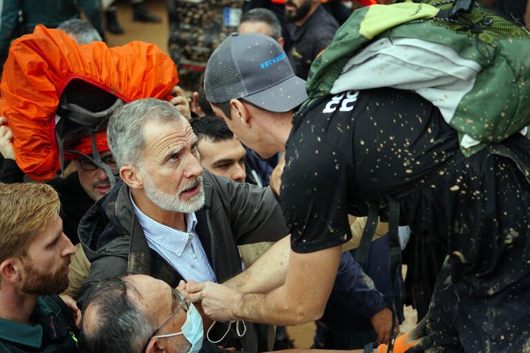 El rey Felipe VI de España (izq.) habla con una persona mientras residentes enojados lo interrumpen durante su visita a Paiporta, en la región de Valencia, este de España. “Asesinos”, “hijos de puta”... Una multitud indignada grita a los políticos que acompañan a los reyes de España cuando llegan a la localidad arrasada por las inundaciones de Paiporta.