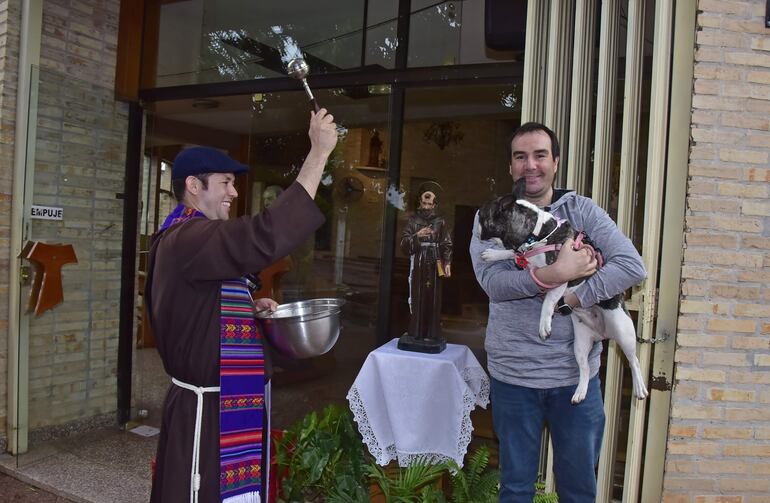 El hermano franciscano Ramón Arévalos bendice a Rufina, una bulldog que llegó en compañía de su familia hasta el convento San Pío de Pietrelcina, en el barrio Trinidad de Asunción.