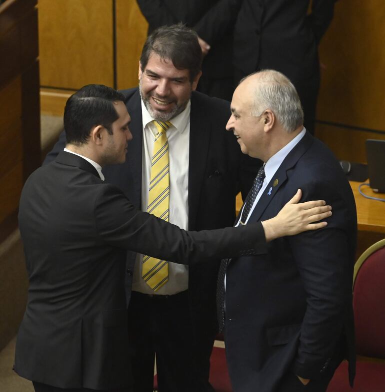 El senador Hernan Rivas (ANR, HC) saluda al diputado Rodrigo Blanco (PLRA) y a  Gustavo Miranda, representante de las Universidades Nacionales ante el CM. 