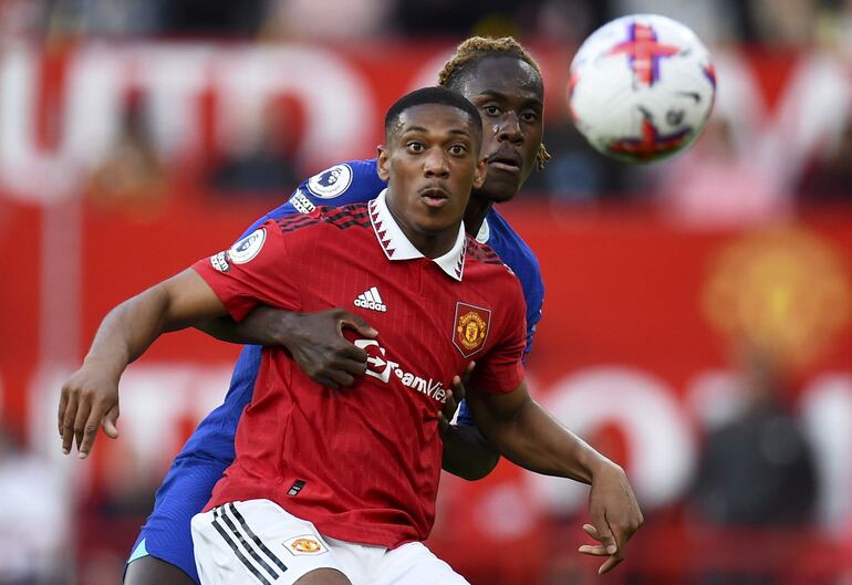 Anthony Martial (de frente) cubre la posesión del balón ante Trevoh Chalobah, del Chelsea, durante el partido que Manchester United ganó ayer por 4-1.