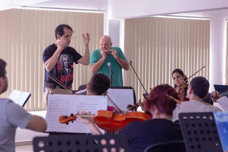 El director Diego Sánchez Haase y el armoniquista José Staneck durante un ensayo con la OSIC.