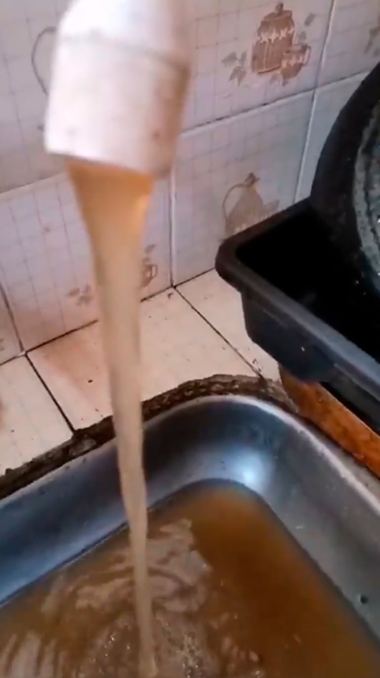 Vecinos de San Vicente exhiben en esta imagen el agua sucia de la Essap.