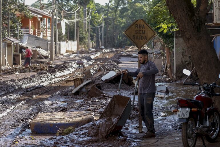 Un hombre retira el lodo que anegó su vivienda tras el desbordamiento del río Taquari, este miércoles en Cruzeiro do Sul, estado de Rio Grande do Sul (Brasil).  