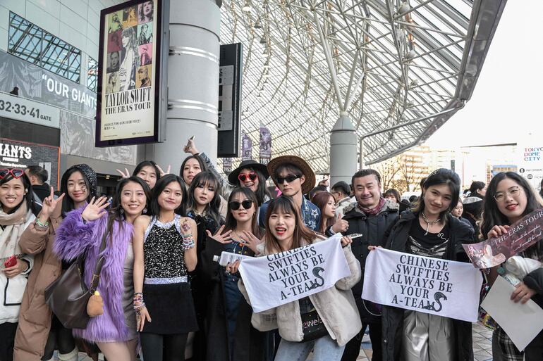 Un grupo de "swifties" chinos posan frente al Tokyo Dome de Japón, donde Taylor Swift iniciará el tramo de su gira asiática.