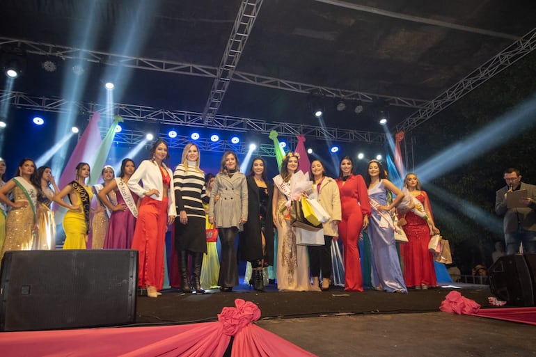 La Miss Primavera con los regalos en su brazo posa con las demás candidatas y organizadores.