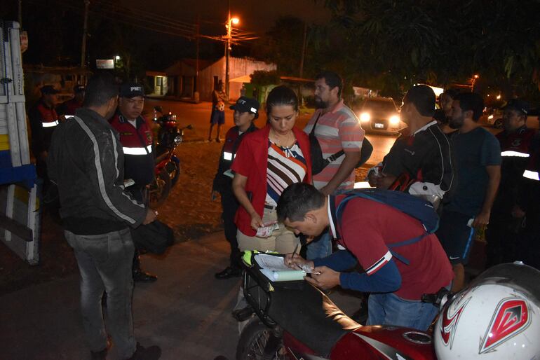 Un funcionario de la municipalidad de Ñemby utiliza el asiento de una moto para preparar el recibo para liberar un rodado.