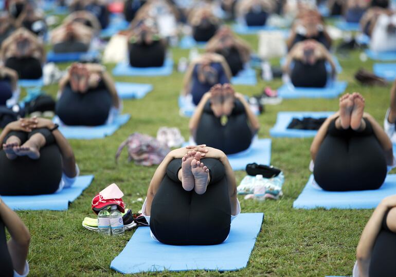 Entusiastas del yoga participan celebran el Día Internacional del Yoga practicando posturas en Bangkok, Tailandia. 