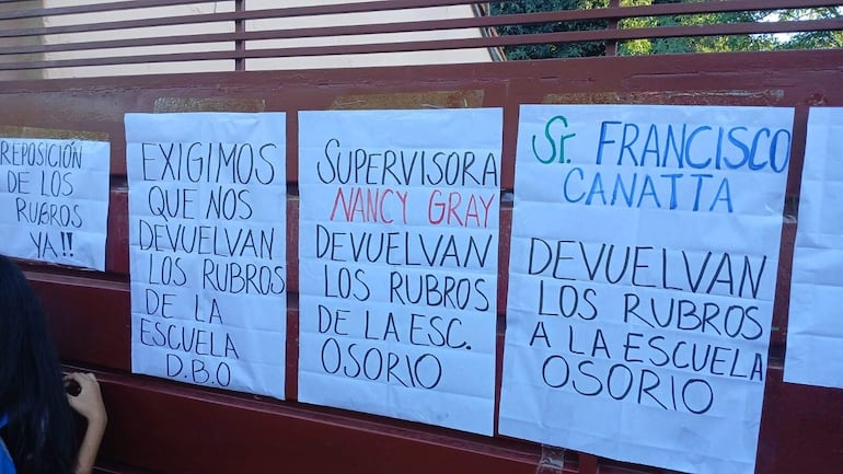 Carteles de repudio contra el director departamental Francisco Canata y la supervisora Nancy Gray.