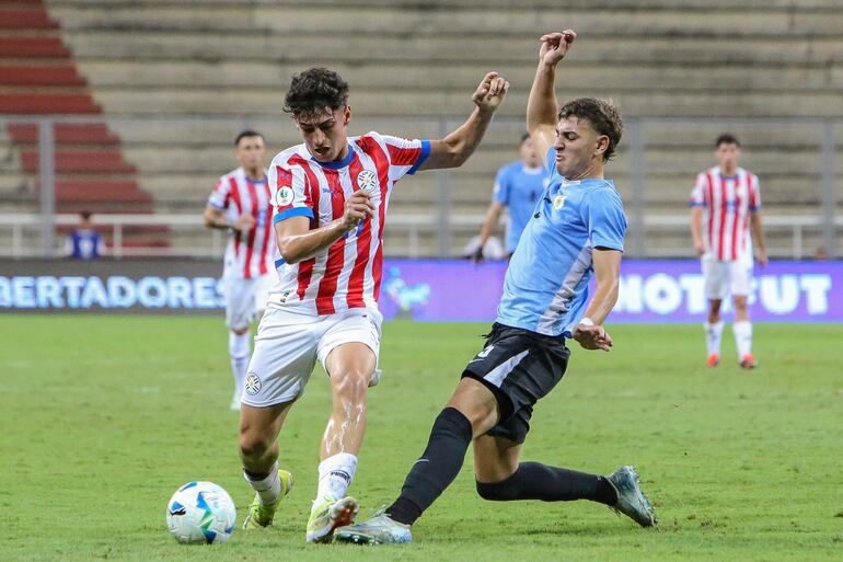 Juan Rodríguez (d) de Uruguay disputa un balón con David Fernández de Paraguay este lunes, en un partido del grupo A del Campeonato Sudamericano sub-20 entre las selecciones de Uruguay y Paraguay en el estadio Metropolitano de Lara en Cabudare (Venezuela).