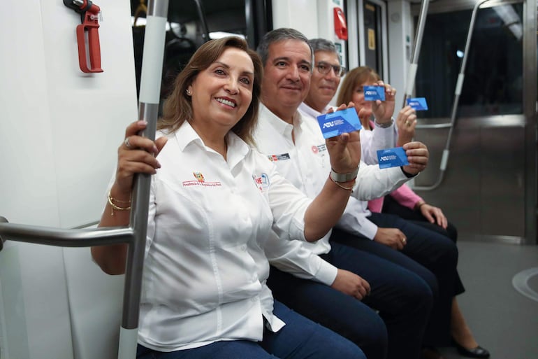 La presidenta del Perú, Dina Boluarte (i), y el ministro peruano de Transportes y Comunicaciones, Raúl Pérez Reyes (2i), muestran las tarjetas del Metro durante su primer recorrido en Lima (Perú).