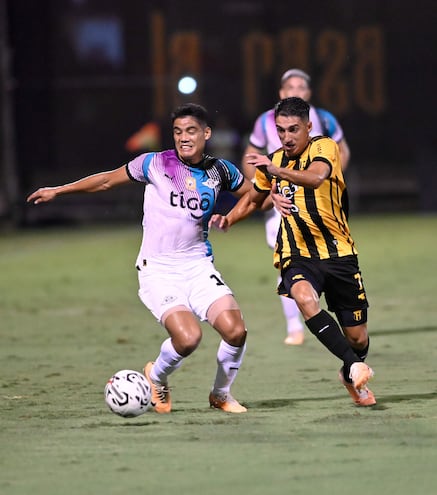 Lorenzo Melgarejo (Libertad) y Enzo Agustín Manzur (Guaraní), pelean el balón en Dos Bocas.