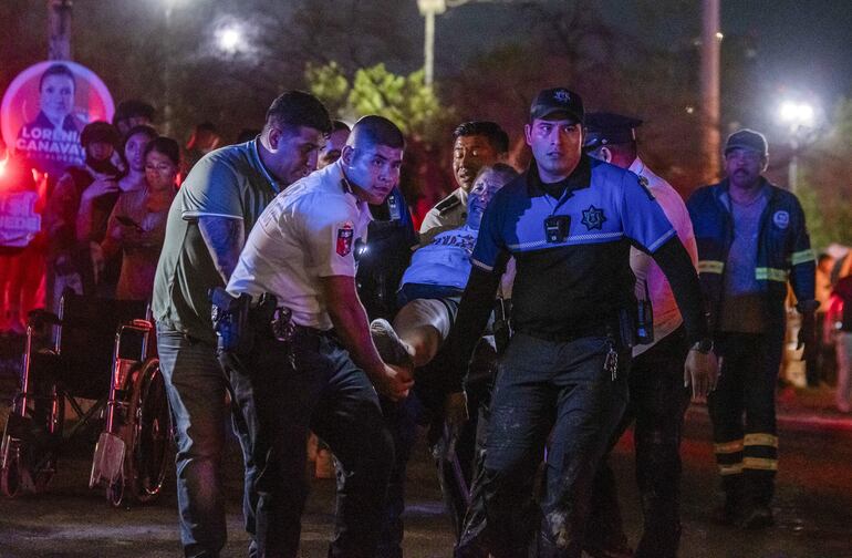 Personal de rescate traslada a personas heridas donde se desplomó un templete durante un acto político de Movimiento Ciudadano (MC), anoche en la ciudad de Monterrey (México).