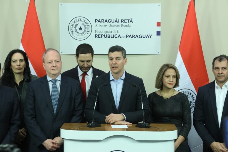 El presidente Santiago Peña (c) rodeado de algunos ministros y  ejemplos de "puertas giratorias", como la ministra de Obras Públicas, Claudia Centurión (izq.) y el ministro de Economía, Carlos Fernández Valdovinos (2do. de la izquierda.) (foto de archivo).