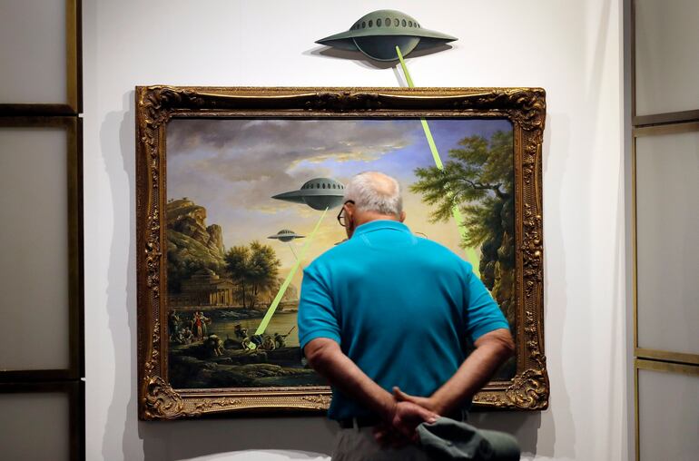 Una persona observa el cuadro 'UFO' (OVNI) por el artista británico Banksy durante la exposición 'El Arte de Banksy' en Berlín, Alemania, el 20 de junio de 2017. EFE/Felipe Trueba