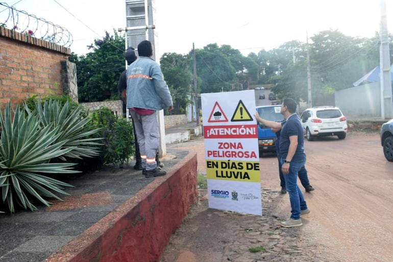 En la ciudad de Villa Elisa instalan carteles en las zonas peligrosas en los días de lluvia.