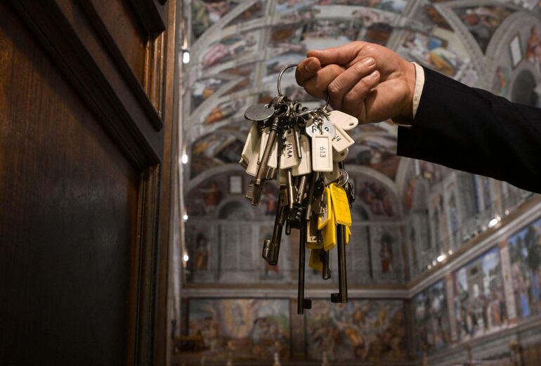 Gianni Crea, guardián de las llaves de los Museos Vaticanos, sostiene uno de los mástiles de llaves en la entrada de la Capilla Sixtina .