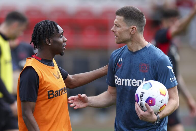 Leverkusen (Germany), 15/05/2024.- Bayer Leverkusen head coach Xabi Alonso (R) talks to player Jeremie Frimpong the traning session of his team during the UEFA Open Media Day in Leverkusen, Germany, 15 May 2024. Bayer Leverkusen will face Atalanta in the UEFA Europa League final on 22 May 2024. (Alemania) EFE/EPA/CHRISTOPHER NEUNDORF
