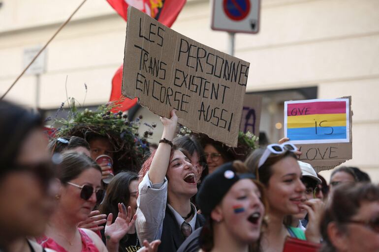 Una mujer sostiene un cartel que dice "Las personas trans también existen en Córcega" durante la marcha del orgullo LGBT "Freedom walk", la primera de su tipo en Bastia, en la isla mediterránea francesa de Córcega.