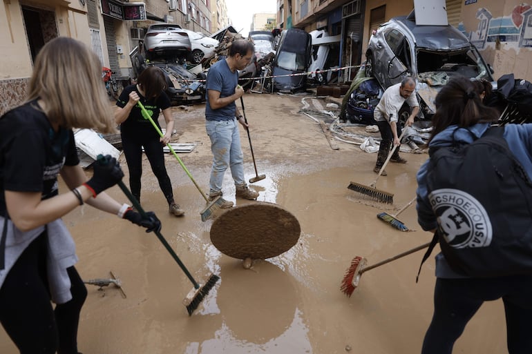 Vecinos y personas de diversas comunidades autónomas trabajan como voluntarios para restablecer la normalidad en Alfafar (Valencia), este viernes. La búsqueda de desaparecidos, la identificación de víctimas mortales, las tareas de limpieza y la reparación de infraestructuras continúan tres días después de las inundaciones.
