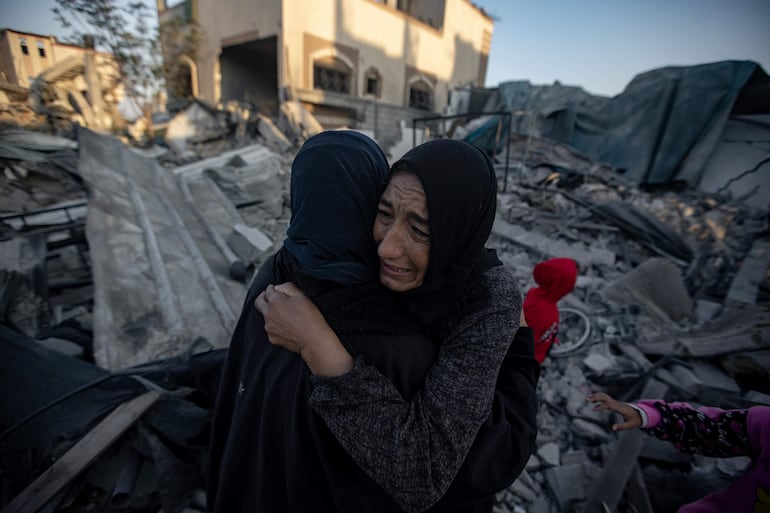 Dos mujeres cerca de los escombros de un edificio destruido por un bombardeo israelí en Jan Yunis, este sábado.