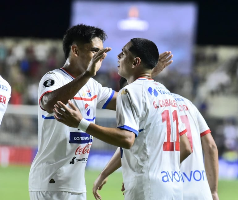 Leandro Meza (i) y Gustavo Caballero, jugadores de Nacional, celebran un gol en el partido frente a Alianza Lima por la ida de la Fase 1 de la Copa Libertadores 2025 en el estadio Arsenio Erico, en Asunción, Paraguay.